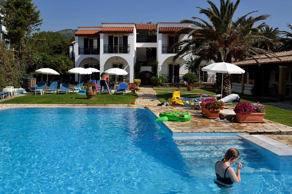 阿查拉维费罗里安酒店式公寓的坐在房子旁边的游泳池里的女人
