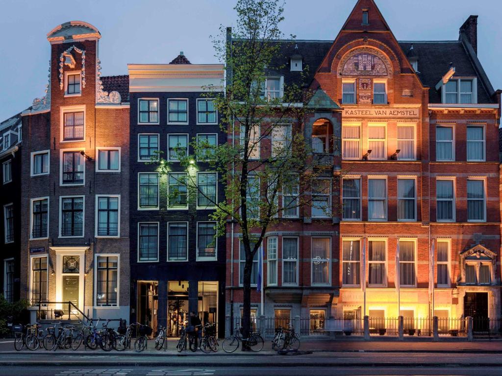 阿姆斯特丹INK Hotel Amsterdam - MGallery Collection的一群自行车停在他们前面的建筑