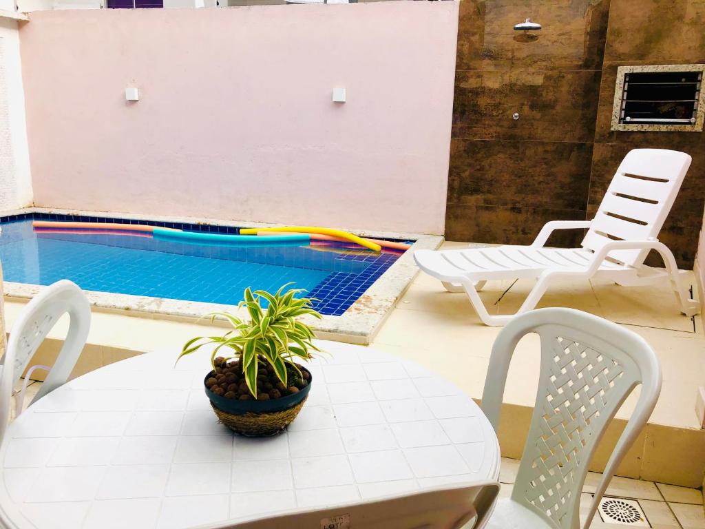 塞古罗港Dúplex em Porto Seguro com piscina a 8 minutos das praias的游泳池旁的桌子上放着植物