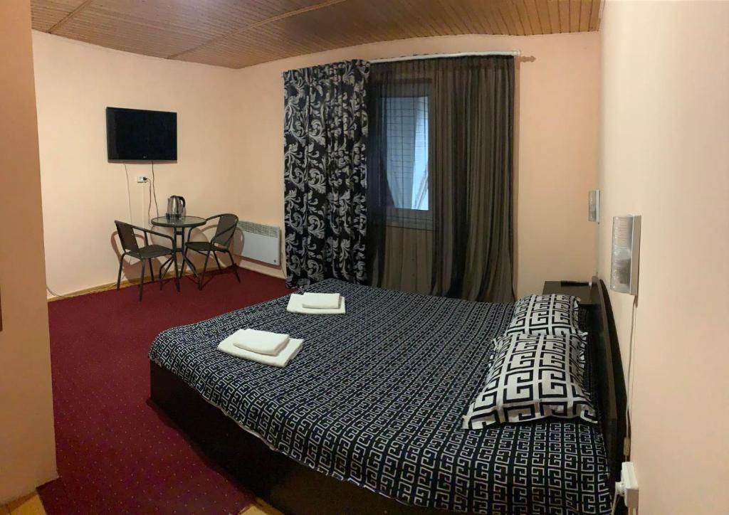 切尔诺夫策Mini-Hotel Sakvoyage的酒店客房配有一张床铺和一张桌子。
