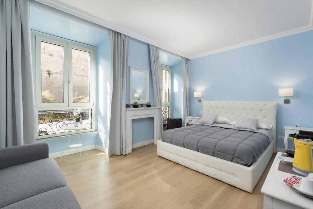 罗马Rhome Hosting的卧室拥有蓝色的墙壁,配有一张床和一张沙发
