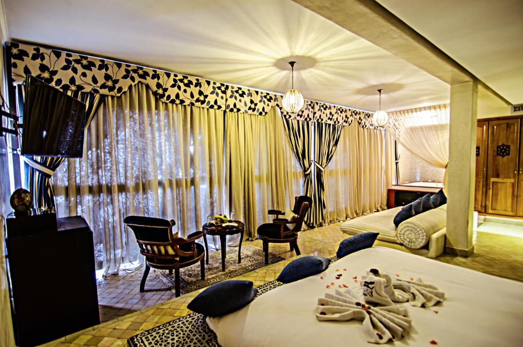非斯奥梅亚宫套房Spa酒店的酒店客房带两张床、椅子和窗帘