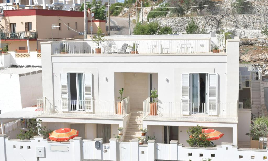 莱乌卡Estatesalento的带阳台和白色围栏的白色房屋