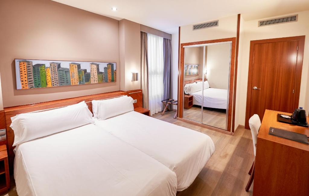 巴塞罗那Garbi Millenni的酒店客房配有白色的床和镜子