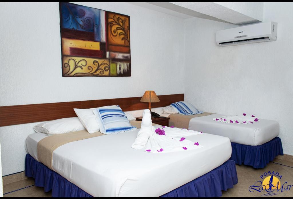 El YaqueHotel Posada La Mar的白色和蓝色的酒店客房内的两张床