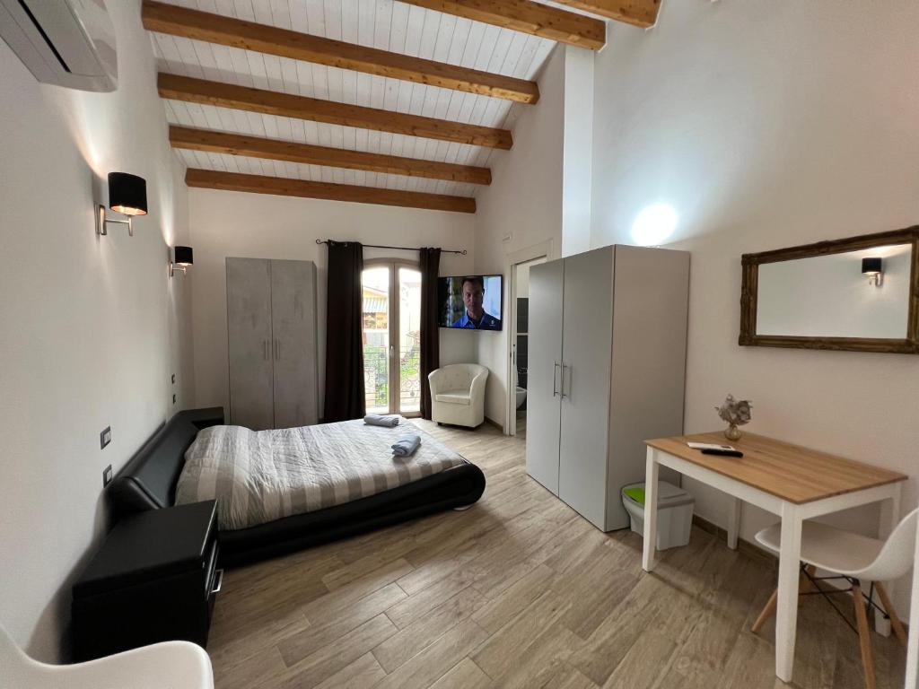 普拉L’ANGELO BIANCO 2的一间卧室配有一张床、一张桌子和一张桌子