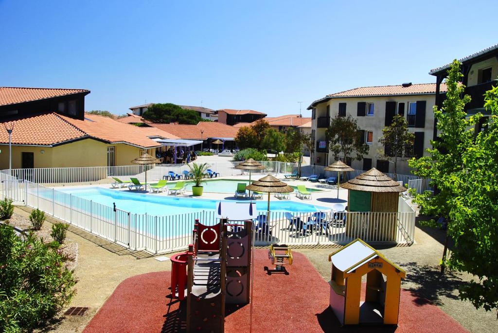 布科·莱斯白老城乐尤卡度假农庄的一座带游乐场的大型游泳池和一座建筑