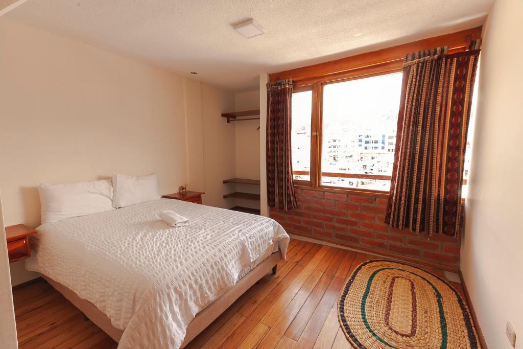 奥塔瓦洛Los Ponchos Inn Apartotel的一间卧室设有一张床和一个大窗户