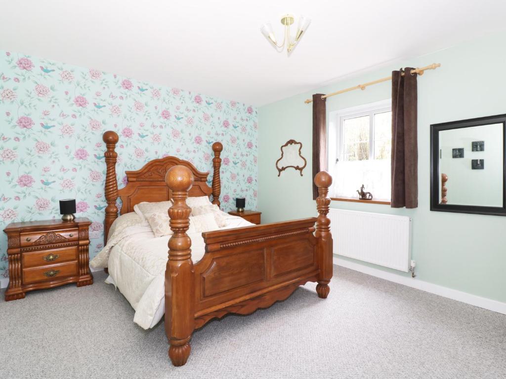 布兰登The Lodge的一间卧室设有一张木床和一个窗户。