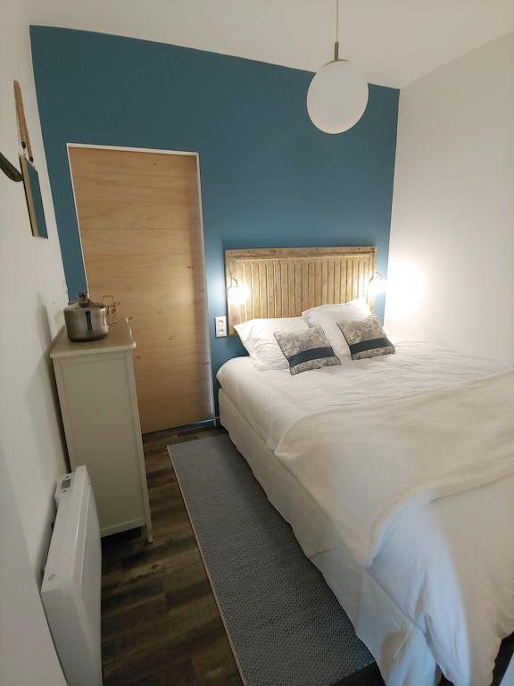 亚眠Appartement 2 personnes : LES CANAUX的一间卧室设有一张蓝色墙壁的大床