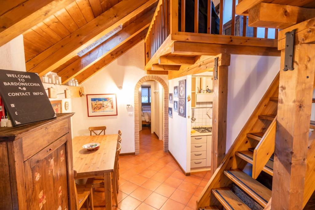 巴多尼奇亚Pochi passi dalle piste di Les Arnaud的房屋内的厨房和用餐室,设有木楼梯