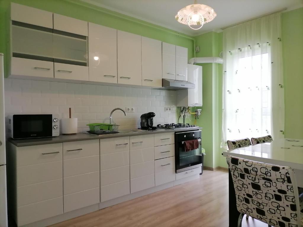 弗洛雷什蒂Apartament NyX的厨房配有白色橱柜和炉灶烤箱。