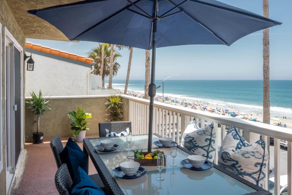 卡尔斯巴德海滩步道别墅的海滩阳台的桌子和遮阳伞