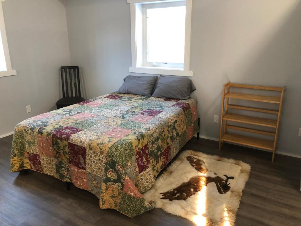 格伦纳伦Copperville B & B的一间卧室,床上有被子,地毯上有一只狗