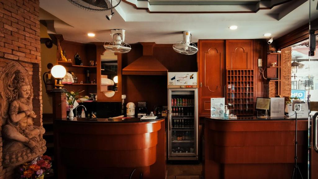 芭堤雅市中心Max Residence的厨房配有木制橱柜、柜台和酒吧。