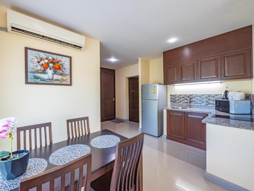 班泰Condo AVANTA Deluxe A201的厨房配有桌椅和冰箱。