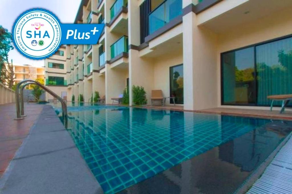 奈扬海滩Airport Beach Hotel Phuket - SHA Extra Plus的大楼前的游泳池