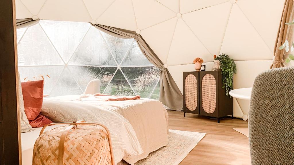 科克赛德Romantische glamping dome Koksijde - Duiniek的帐篷内的卧室配有床和浴缸