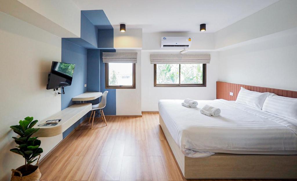 闵埔丽Saffron Hill Minburi的一间卧室配有一张床、一张书桌和一台电视。