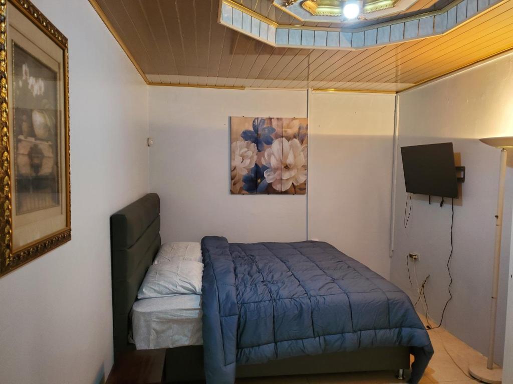 Trincity Preferred Place的卧室配有一张床,墙上挂有绘画作品