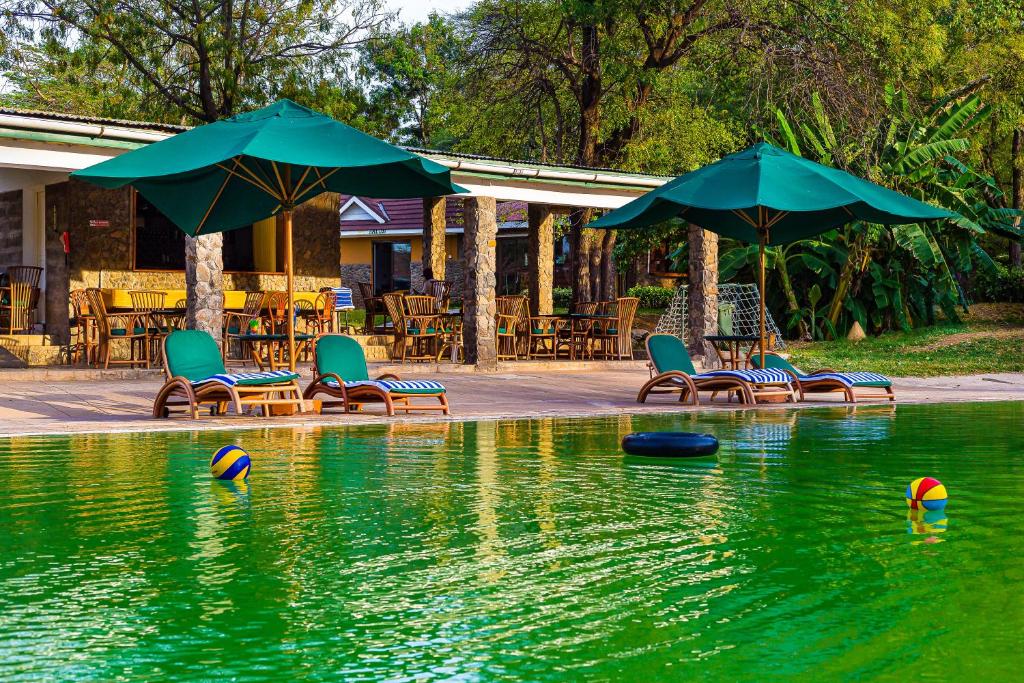 Marigat柏哥利亚湖Spa度假酒店的一个带椅子和遮阳伞的游泳池