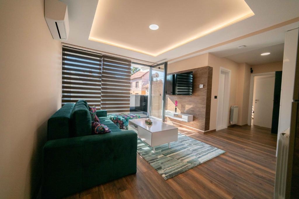 萨拉热窝Luxury Apartments Una Sarajevo的客厅配有绿色沙发和桌子