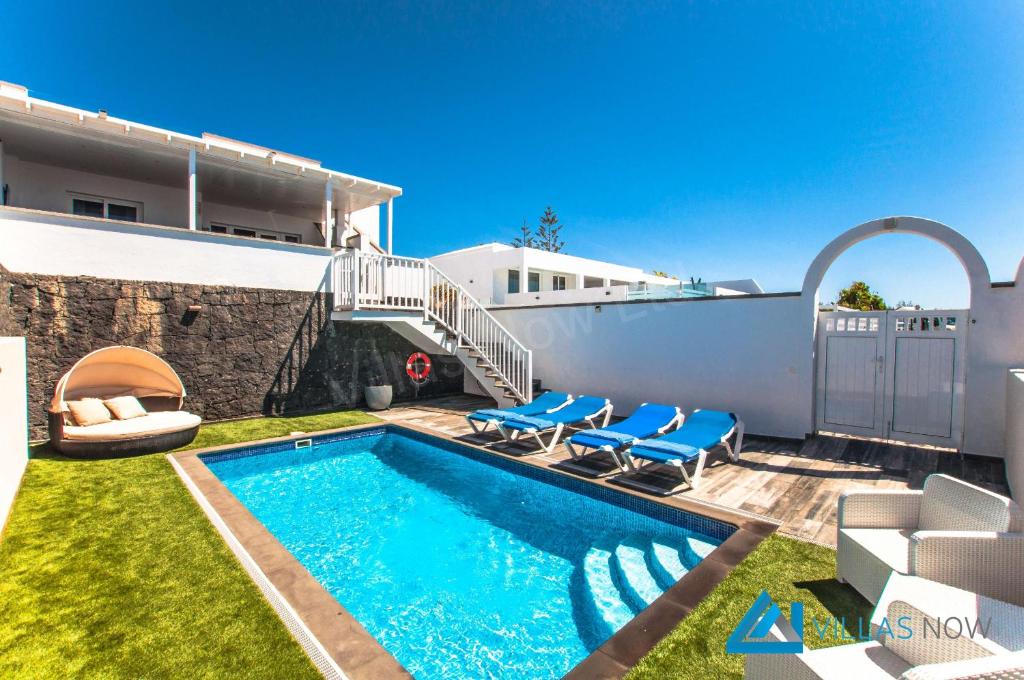 普拉亚布兰卡Villa Graciosa By Villas Now Ltd的一个带蓝色椅子的游泳池
