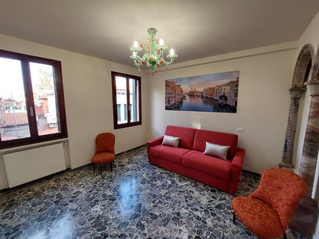 威尼斯Residenza Donini in Venice Suite 1的客厅配有红色的沙发和两把椅子