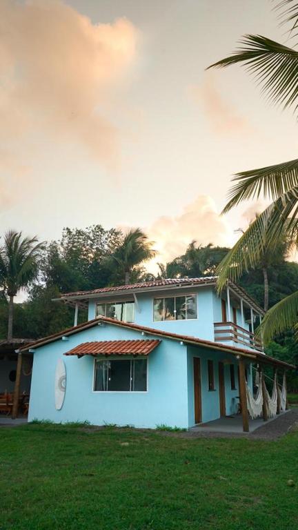 大塞拉Welove Beach House-Pés na areia Quintal dos Sonhos的一座棕榈树掩映的白色房子
