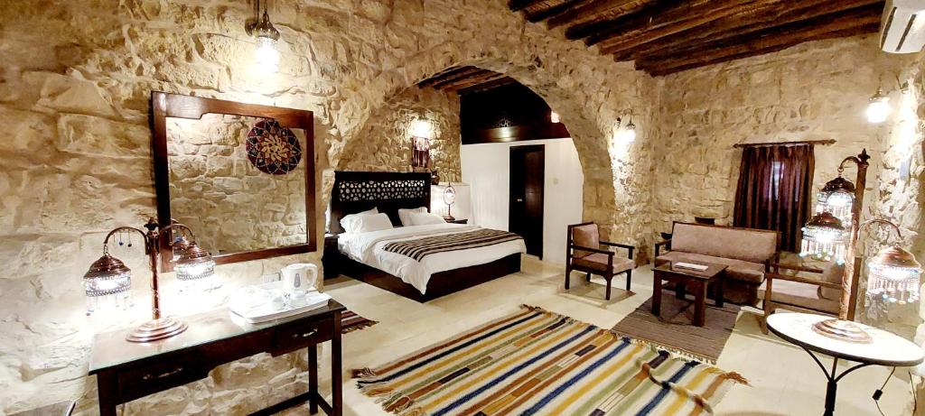 瓦迪穆萨Hayat Zaman Hotel And Resort Petra的一间卧室,卧室内配有一张床和一把椅子