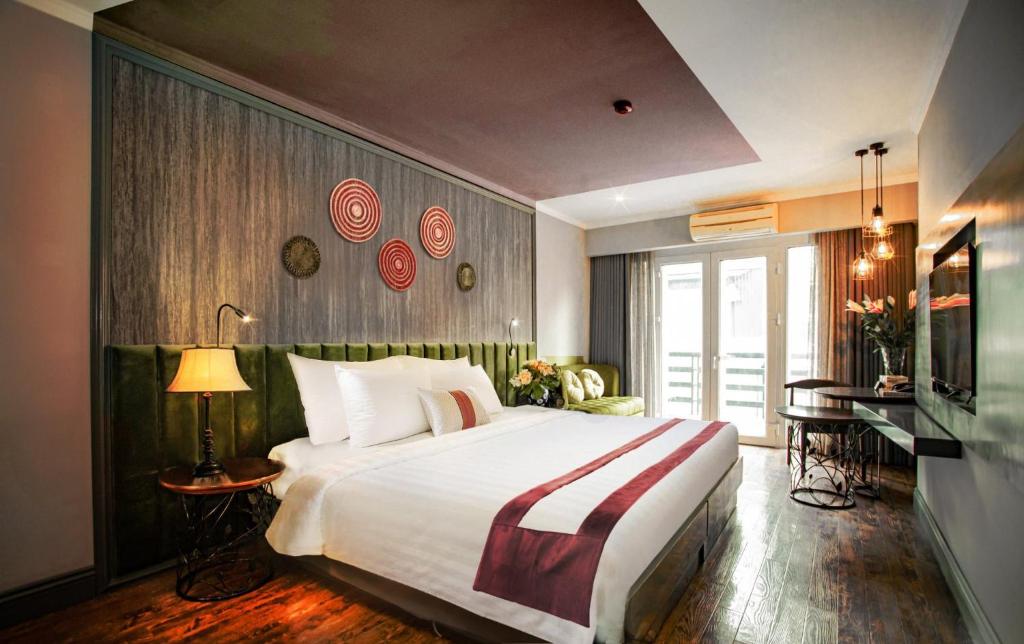 河内Hanoi Center Silk Hotel & Travel的酒店客房设有一张大床和一张书桌。