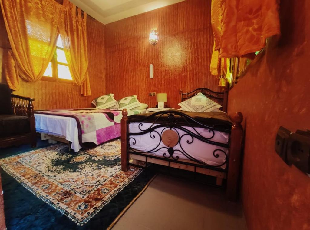 穆莱伊德里斯Kasabah Senhaji的一间卧室设有两张床和窗户。