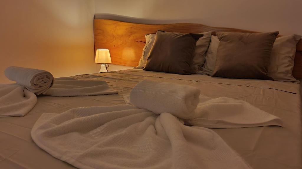 雅帕拉廷加Japaratinga Suites的一张带白色床单和毛巾的床