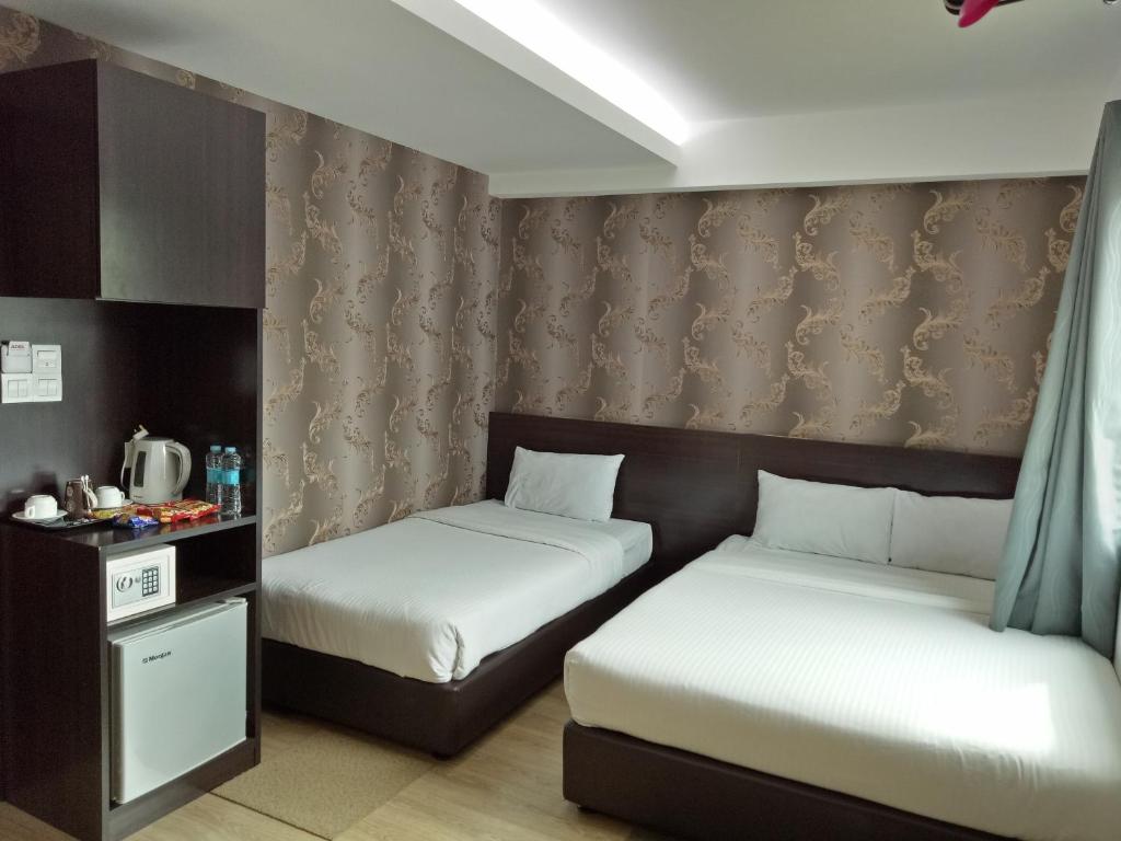 Juru7 Hotel的客房设有两张床、一张桌子和窗帘