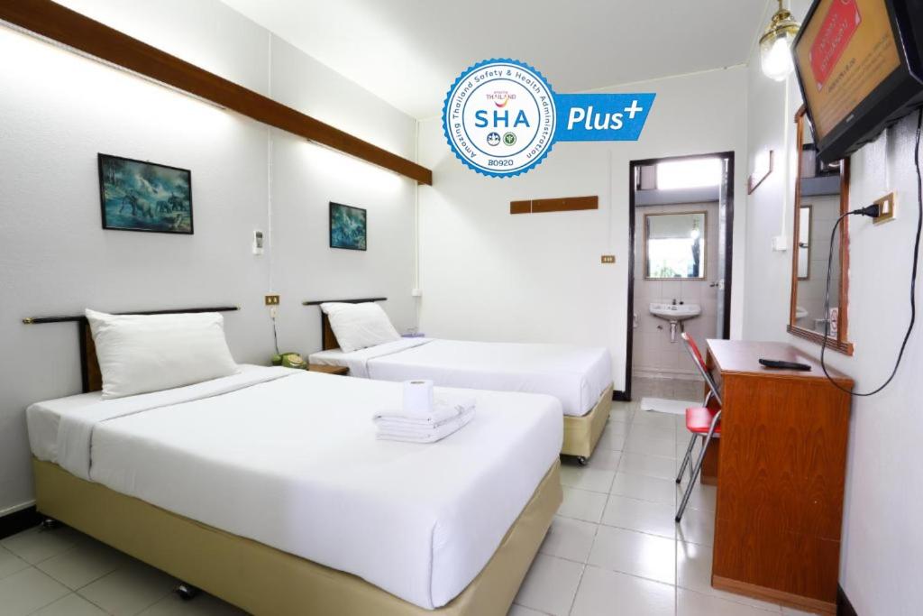 清迈Chomdoi House Hotel SHA Extra Plus的酒店客房设有两张床和一个可读歌的标志