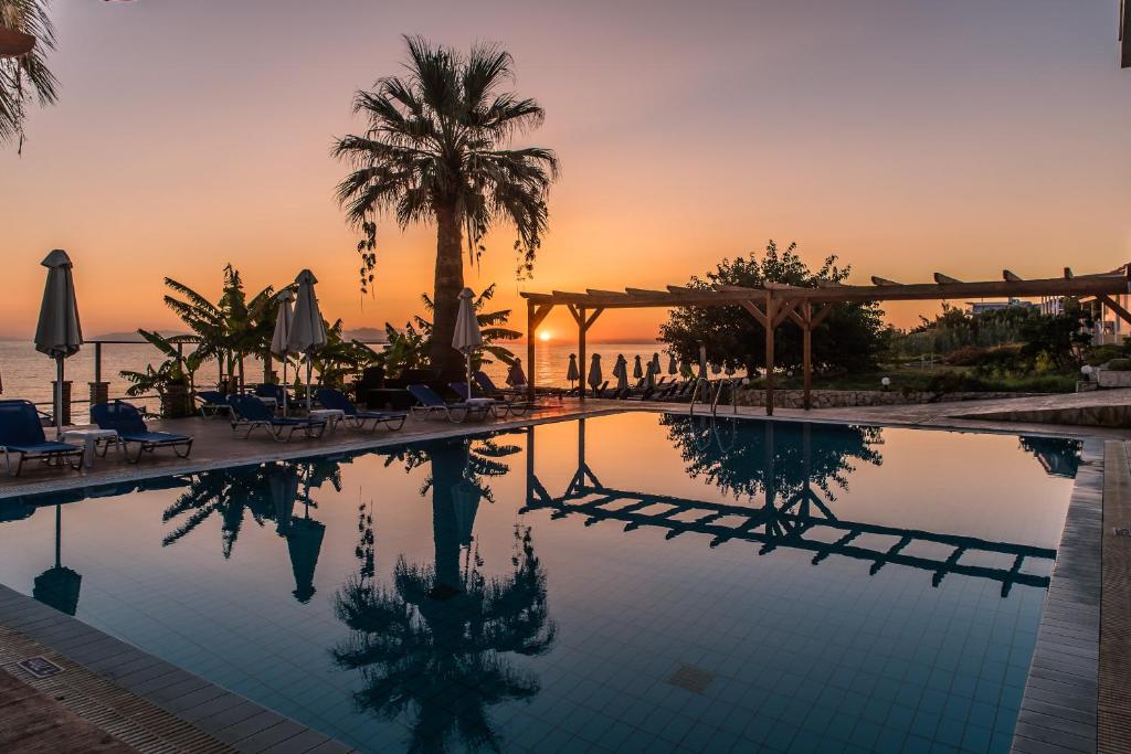 基普塞利Belussi Beach Hotel & Suites的一座享有日落美景的游泳池