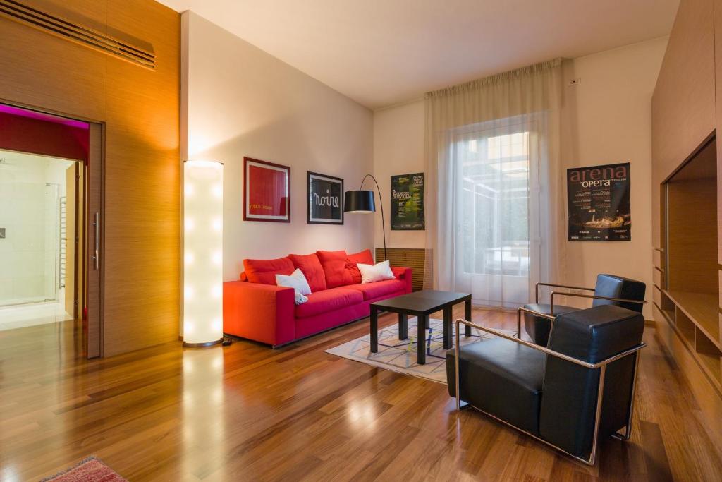 维罗纳维罗纳中心竞技场公寓的客厅配有红色的沙发和桌子