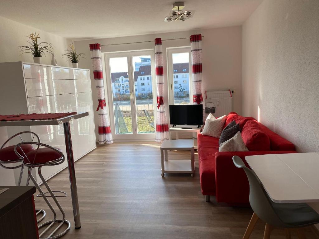 辛根Apartment- Singen Überlinger Straße的客厅配有红色的沙发和桌子
