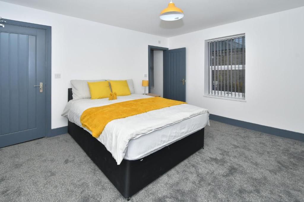 EtruriaTownhouse @ 24 Brunswick Place Stoke的一间卧室配有一张带黄色毯子的大床