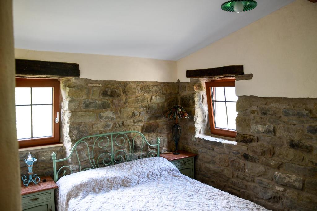 阿普里卡莱CASA LUCERTOLA的一间卧室设有一张床和石墙