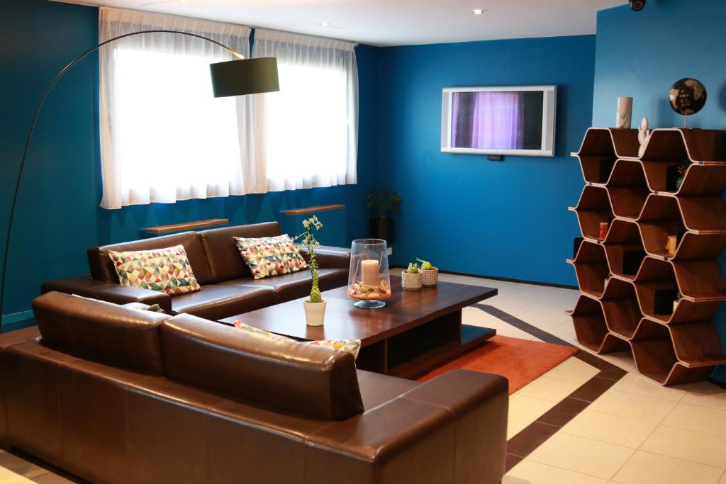 阿蒂斯蒙斯奥利高级酒店的客厅设有棕色沙发和蓝色的墙壁。