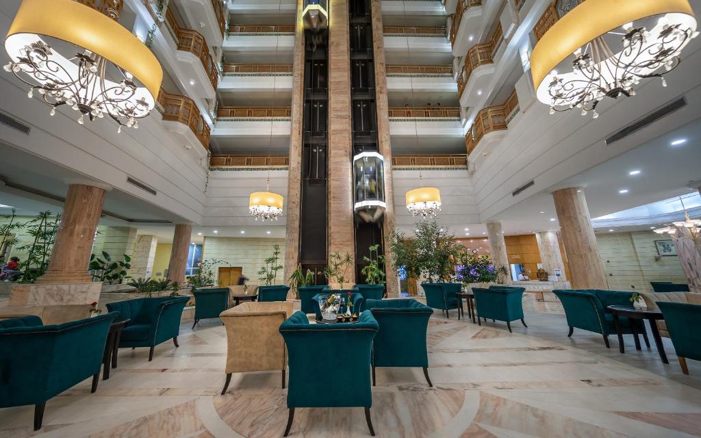 苏塞马哈巴皇家塞勒姆酒店 - 仅限家庭的大型大堂设有桌椅和吊灯。