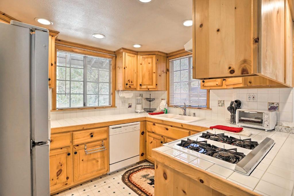 大贝尔城Cozy Cottage with Spacious Yard about 4 Mi to Ski!的厨房配有木制橱柜和炉灶烤箱。