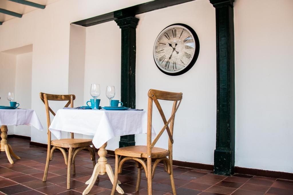 瓜杜阿斯Camino a Santa Fe的一张桌子,两把椅子和墙上的时钟