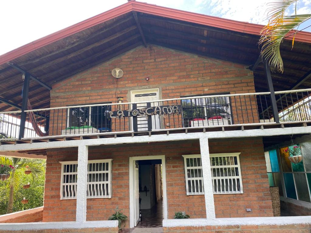 索佩特兰Finca Sopetrán Antioquia的一座砖砌建筑,上面设有阳台