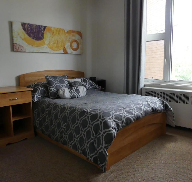 魁北克市812乡间度假别墅的一间卧室配有一张床、一张书桌和一个窗户。