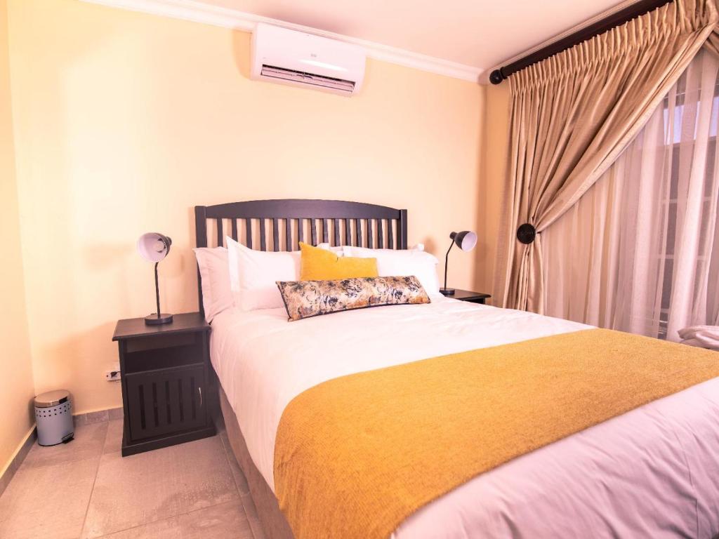 AcornhoekMasingitana Hotel的一间卧室配有一张带黄色毯子的大床