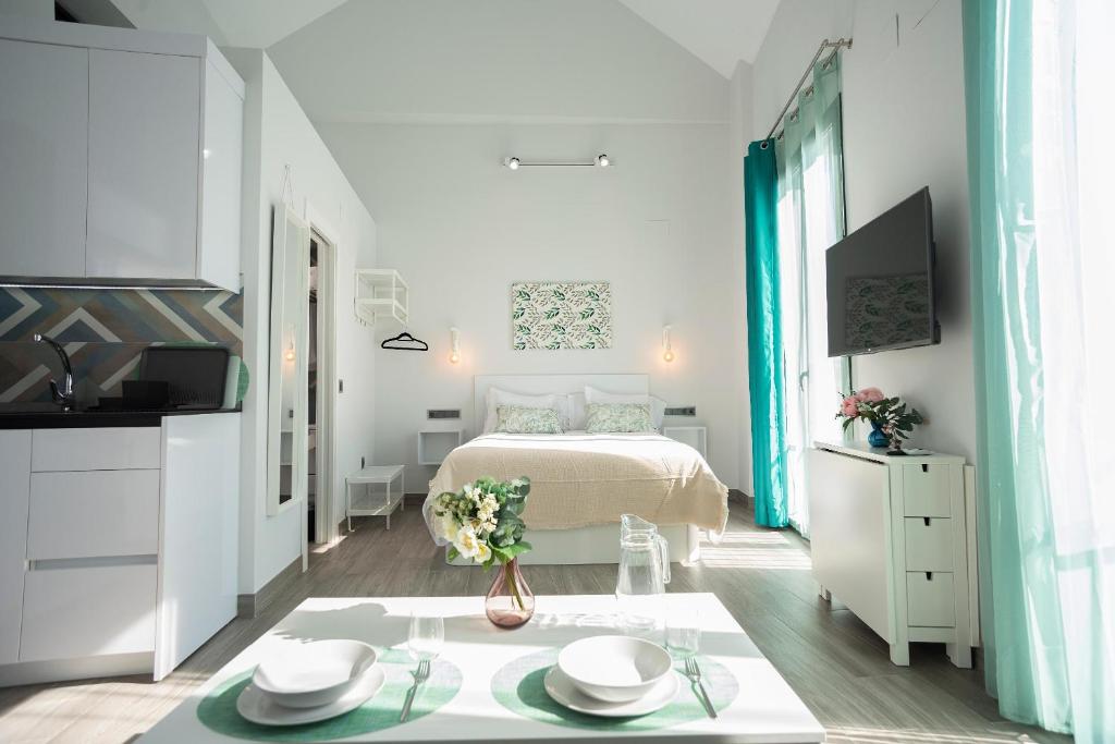 科尔多瓦EM21 Apartamentos的一间白色的小卧室,配有一张床和一张桌子