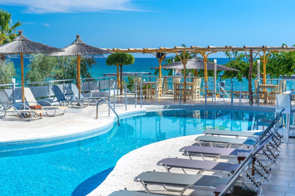 利迈纳里亚Sunray Hotel的一个带躺椅的游泳池和海洋