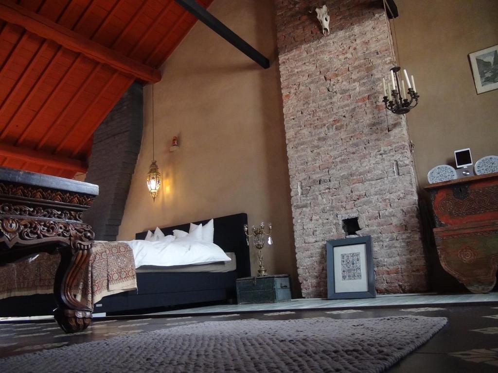 列日蒂博别墅住宿加早餐旅馆的一间卧室设有一张床和砖墙